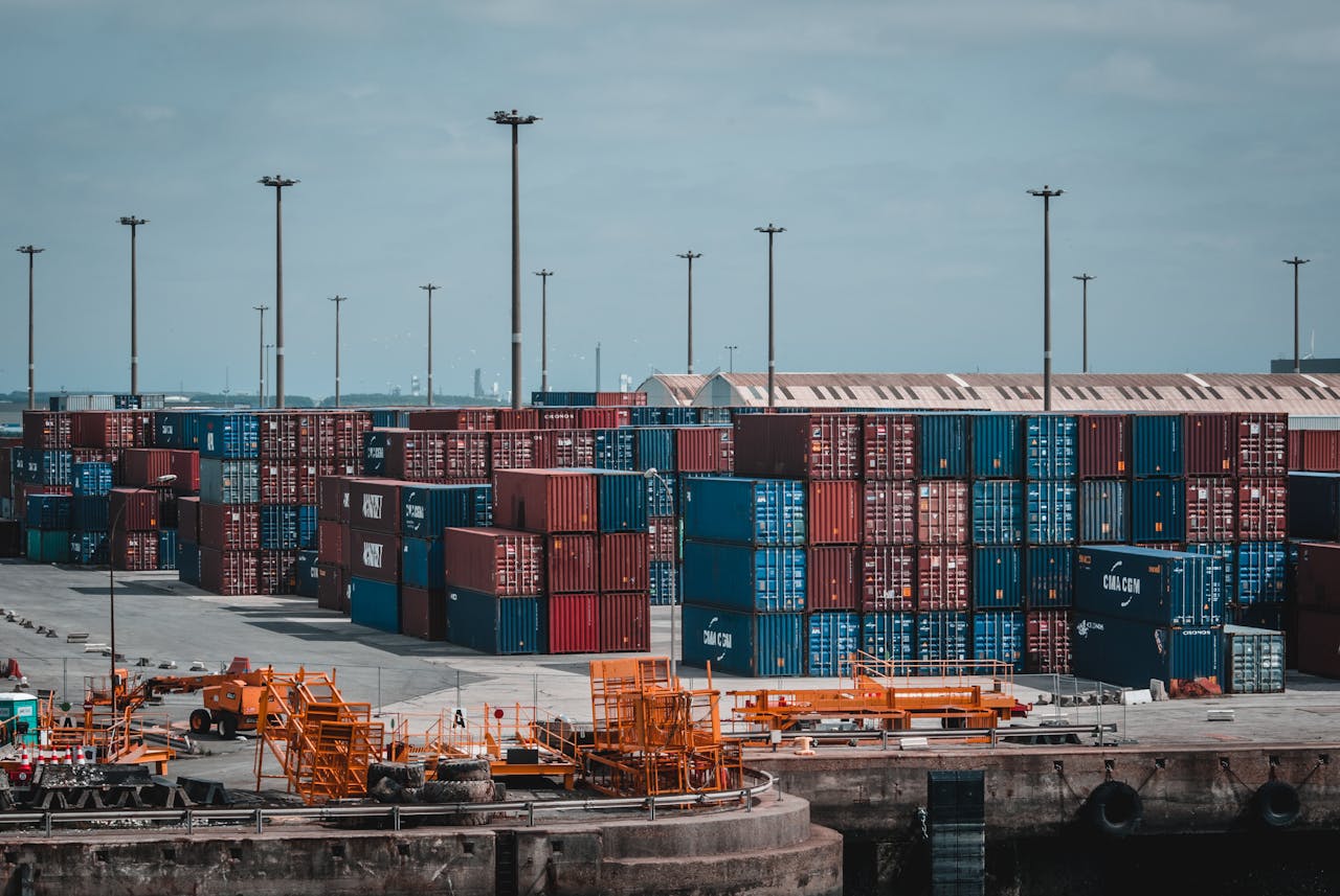 Home Colorful cargo containers stacked at a busy industrial port, showcasing global trade.